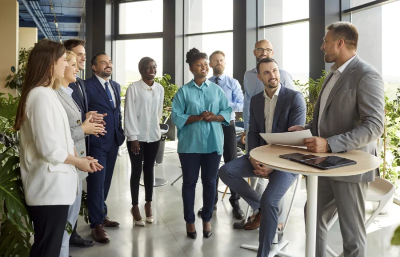 A team of business individuals gathered around a table, strategizing for the Small Business Partnerships Program.